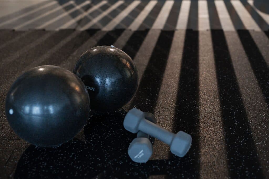 Gimnastikos kamuoliai ir svarmenys ant studijos grindų