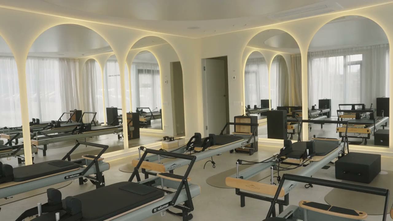 Motus studijos salė Nemunaičių g. 6: reformeriai po arkomis, veidrodinė siena ir dienos šviesa pro užuolaidas